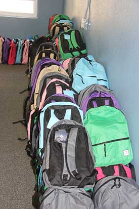A large display of backpacks that were obtained to ensure each child in the Wings program has the things they need for school.
